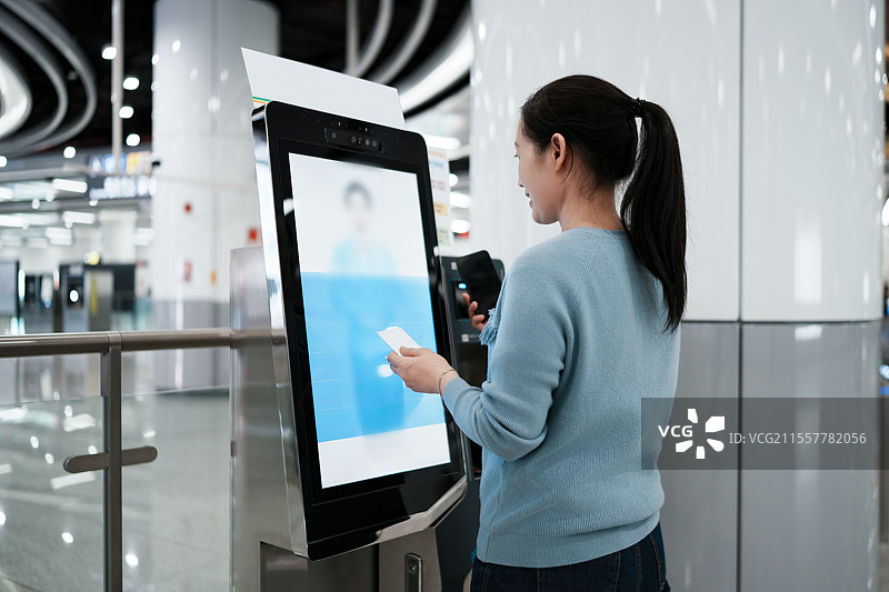 女性使用现代支付亭进行高效交易图片素材