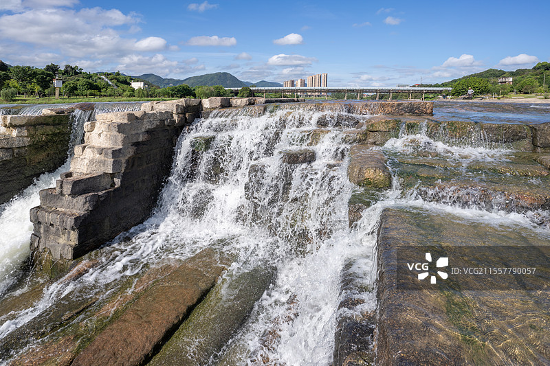 莆田木兰溪清澈的水流湍急，淌过木兰陂的岩石图片素材