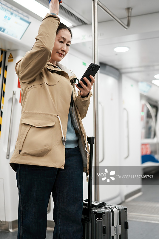 年轻的旅客在地铁与智能手机和行李图片素材