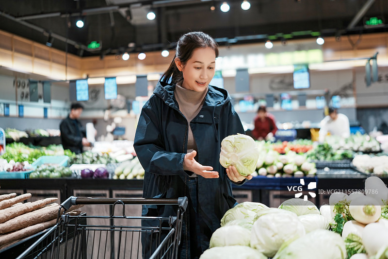 在杂货店挑选新鲜蔬菜的快乐购物者图片素材