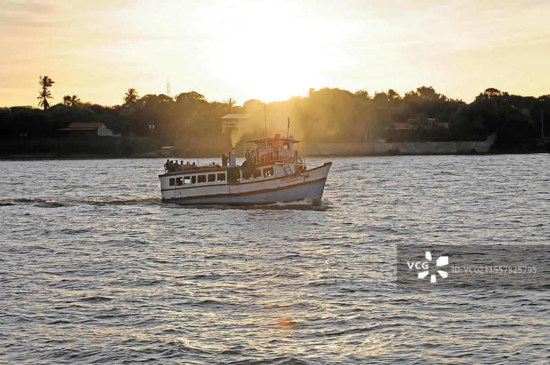 尼加拉瓜湖，背景是奥梅特佩岛，日落时分湖面上的小船，水面上有光的倒影，船上的剪影，尼加拉瓜，中美洲。图片素材