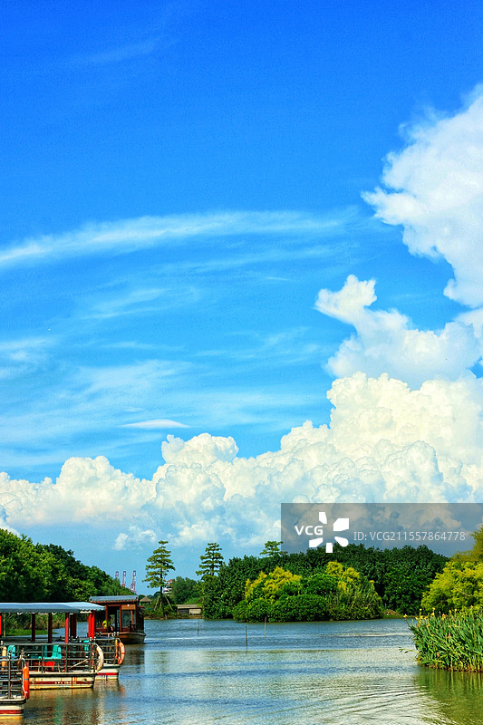 广州南沙湿地公园蓝天白云积雨云高积云游船小船绿树河流溪流河水夏天夏季旅游旅行游览名胜景区度假游玩自然图片素材