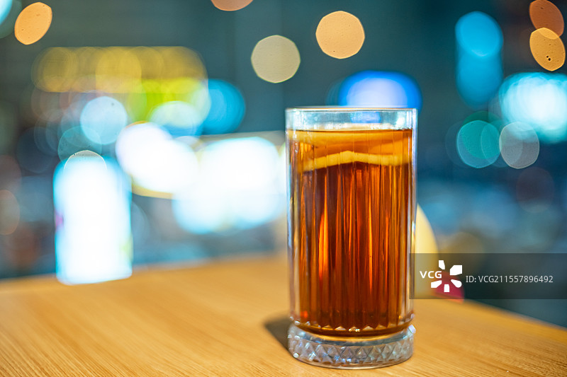 中国城市健康生活拍摄主题，茶几上玻璃杯大红袍暴打柠檬水，背景是城市夜景，室内无人图像摄影图片素材