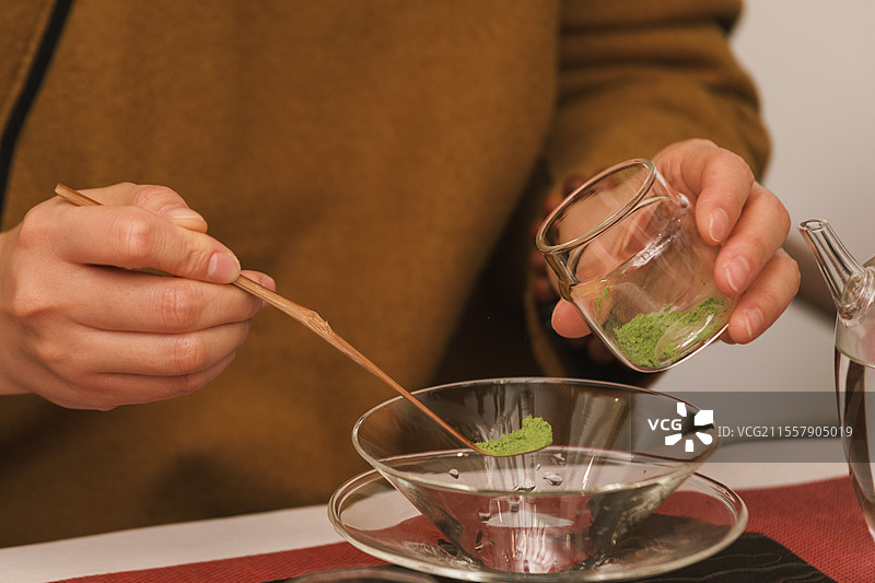 女士一边用茶筅搅拌抹茶粉 ，一边用传统的茶道用具制作有机绿色抹茶 抹茶 绿茶 茶粉图片素材
