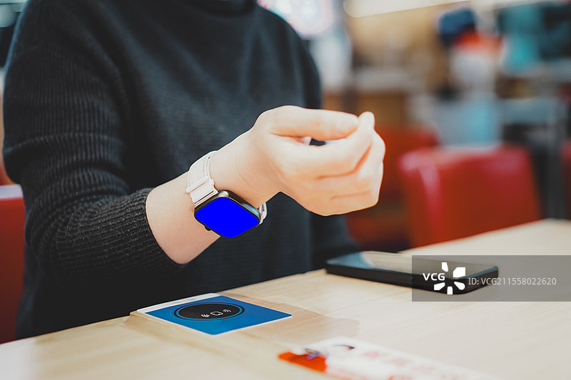 舒适咖啡馆环境中的现代智能手表交互图片素材