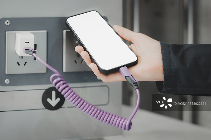 现代智能手机用线圈电缆在电源插座充电图片素材