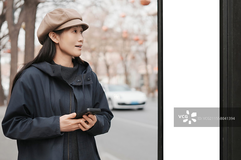 城市环境中在公交车站等候的时尚女性图片素材