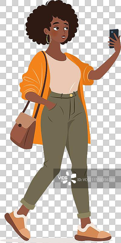 年轻女性走路时使用智能手机图片素材