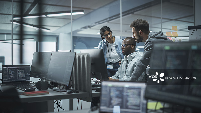 程序员们围坐在桌面电脑旁图片素材