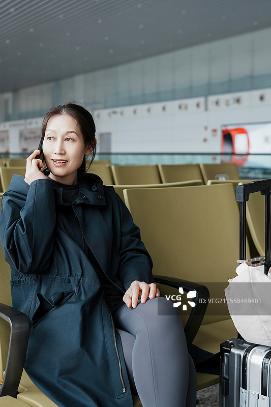 现代旅行者在机场打电话时放松身心图片素材