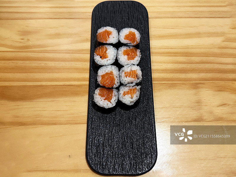 木制条纹桌上盘子里的炙烧三文鱼寿司特写高角度镜头图片素材