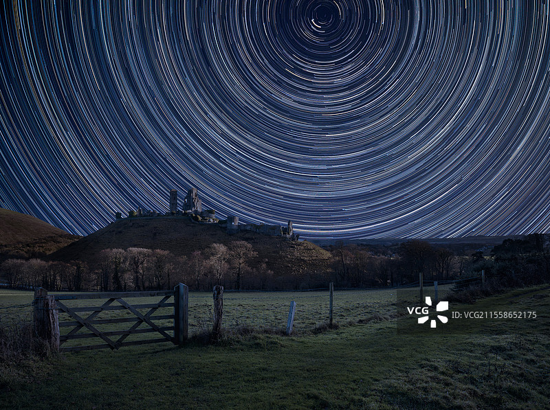 数字合成图像，展示了北极星周围的星轨以及壮观的中世纪城堡遗址风景。英国图片素材