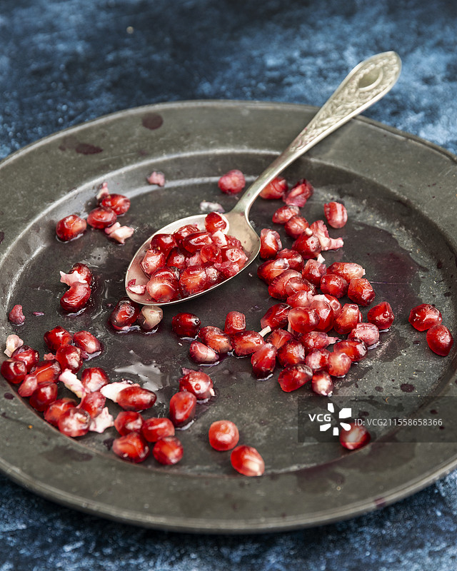 美丽的食物肖像，展示了撕开的石榴和种子，背景为复古质感。图片素材