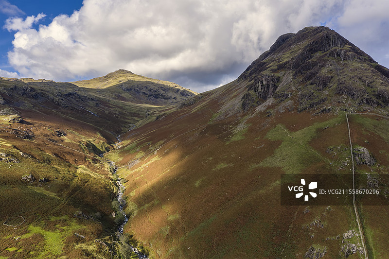 令人惊叹的高空视角，飞行无人机俯瞰夏末的湖区风景，位于瓦斯特湖谷，背景是山脉景观。图片素材