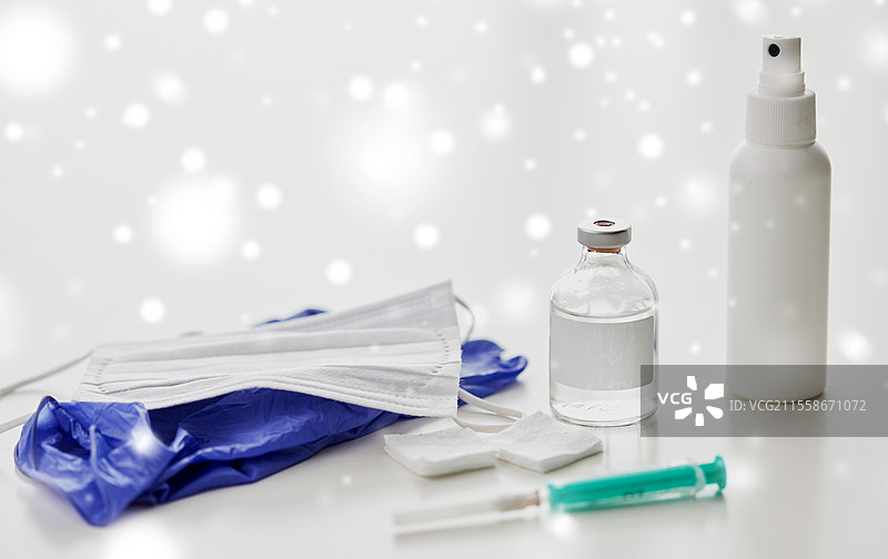 医学和医疗概念 - 冬季雪地上桌子上的注射器、药物、伤口清洁湿巾、手部消毒液、手套和口罩的特写。注射器、药物、伤口清洁湿巾、手套和口罩。图片素材