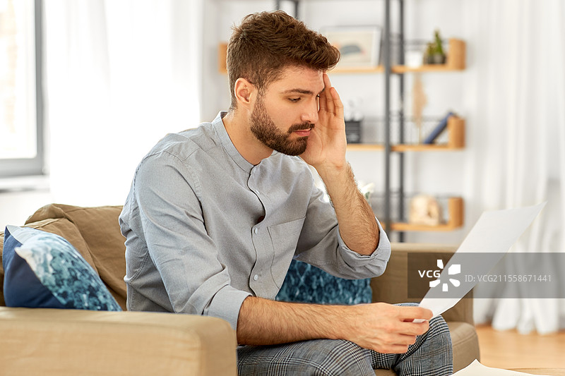 商业、财务、会计和人们的概念 - 在家中对账单或税务报告感到不满的男人。图片素材