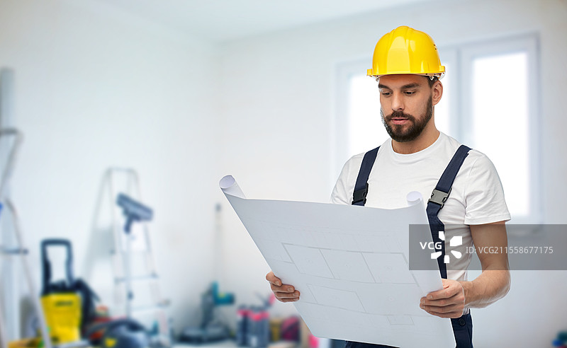 修理、建筑和施工概念 - 戴着安全帽的男性工人或建筑工人在背景中有设备的房间里拿着蓝图。图片素材