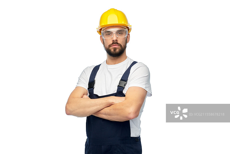 职业，建筑和施工 - 戴着黄色安全帽和护目镜的男性工人或建筑工人，双臂交叉，背景为白色。双臂交叉的男性工人或建筑工人。图片素材