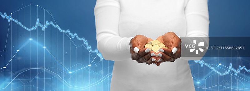 金融、货币与人们的概念 - 非洲裔美国女性手握钞票，背景为蓝色虚拟图表。非洲裔美国女性手握钞票的特写。图片素材