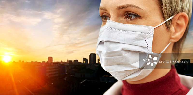 健康、安全和疫情概念 - 年轻女性在日落背景下佩戴防护口罩的特写。年轻女性佩戴防护口罩。图片素材