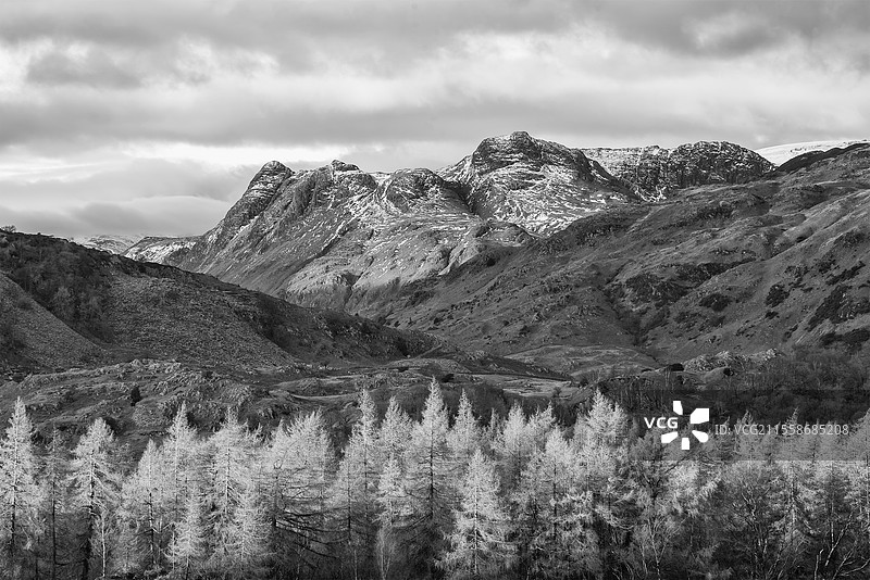 史诗般的冬季黑白风景图，视角来自湖区的霍尔梅山，远处雪山在辉煌的晚光中显现。图片素材