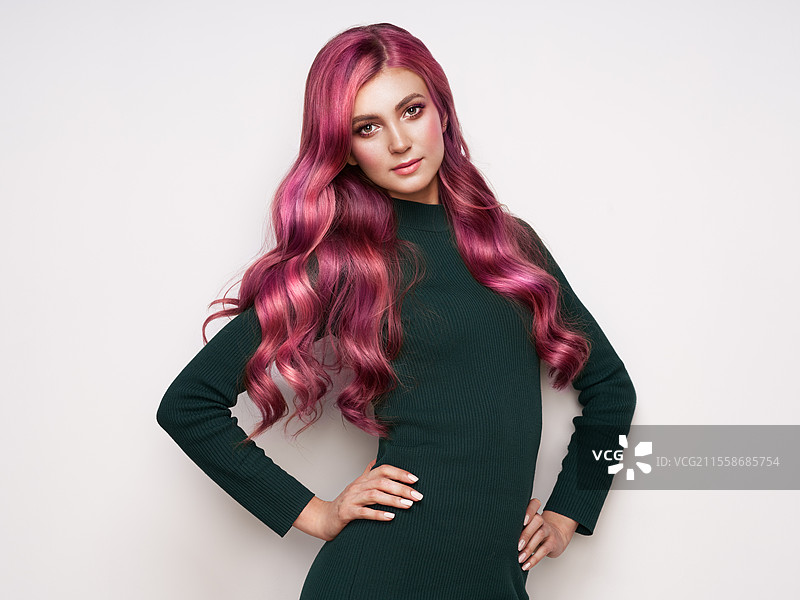 穿着针织裙的美丽女性。长发健康光泽的棕发女孩，拥有卷曲的粉色头发。护理与美丽。拥有波浪发型的美丽模特。秋季服装。图片素材