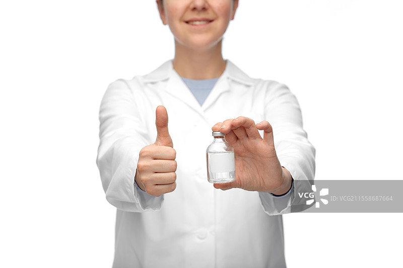 医学、疫苗接种和医疗保健概念 - 开心微笑的女性医生或护士手持药瓶，竖起大拇指，背景为白色。医生手持药物竖起大拇指的特写。图片素材