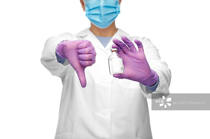 医学、疫苗接种和医疗保健概念 - 女性医生或护士戴着口罩，手持药瓶，白色背景下竖起大拇指向下。医生手持药物竖起大拇指向下。图片素材