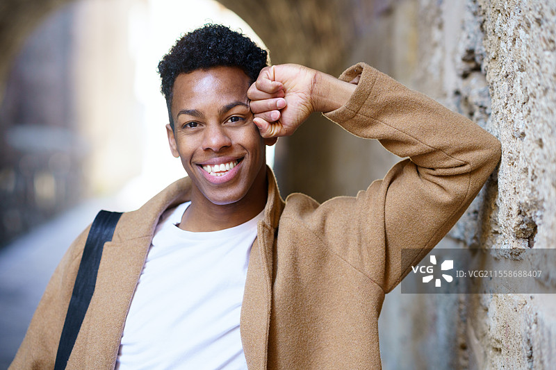 快乐的黑人男子在户外对着镜头微笑。古巴学生在城市背景中。快乐的黑人男子在户外对着镜头微笑。图片素材