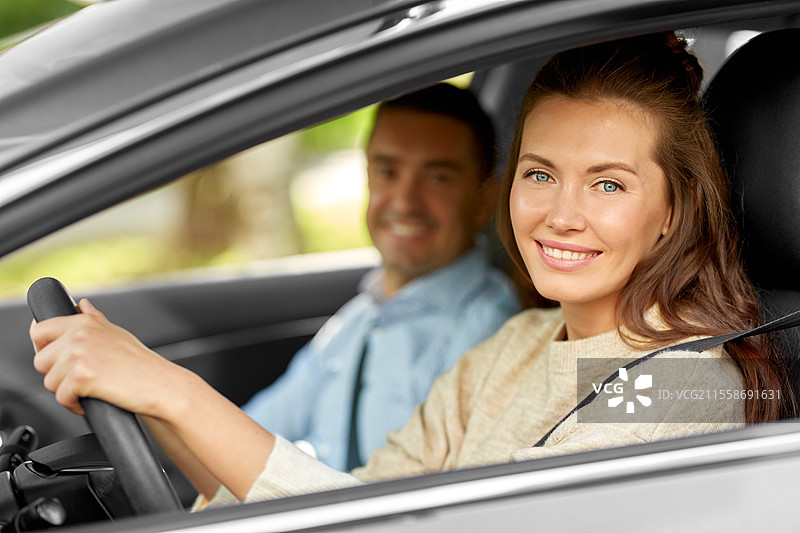 驾驶课程与人们的概念 - 汽车驾驶学校的教练教年轻女性驾驶。汽车驾驶学校的教练教女性。图片素材