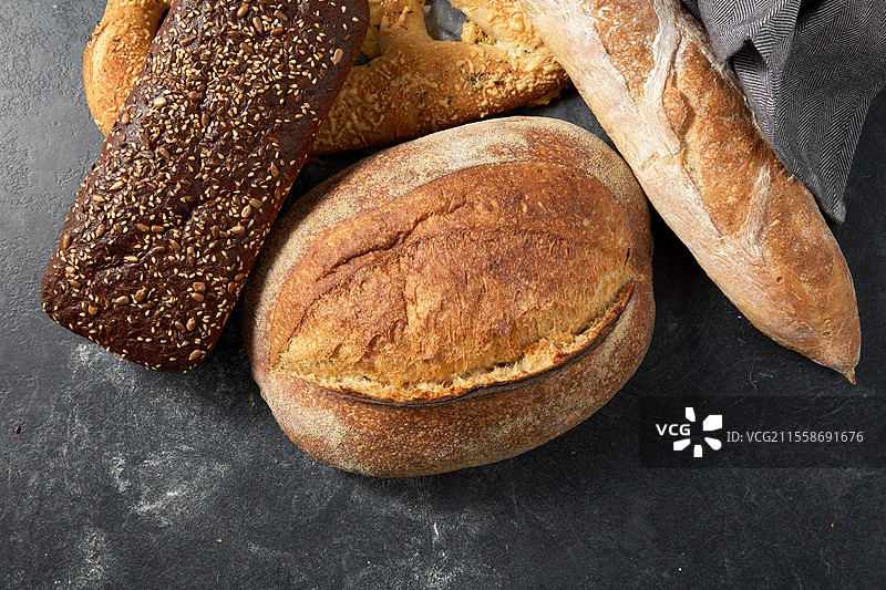 食物、烘焙和烹饪概念 - 厨房毛巾上的各种面包特写。图片素材