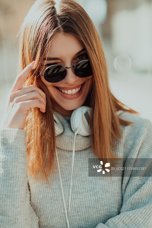 两个年轻女孩在山间大自然中驾驶越野车，享受美丽的阳光明媚的一天，面带快乐的笑容。图片素材