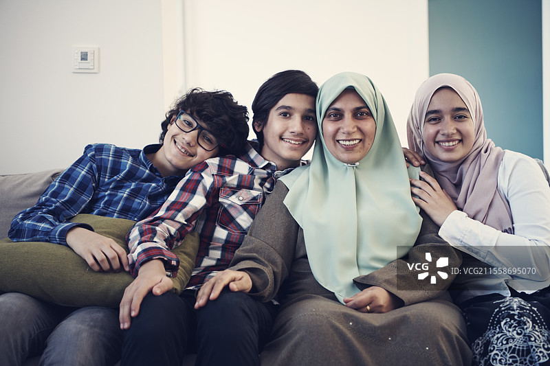 中东家庭肖像，单身母亲与青少年孩子在家中的客厅里图片素材