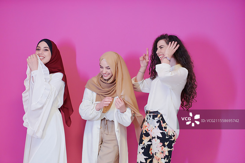 年轻的非洲美女穿着传统伊斯兰服装，背景为粉色塑料。图片素材