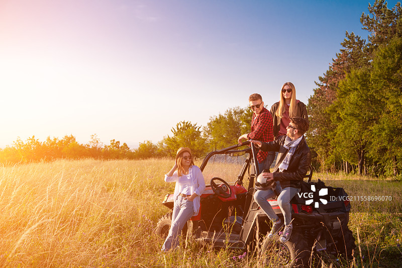 一群年轻快乐的人在阳光明媚的日子里，驾驶越野车享受山间大自然的美好时光。图片素材