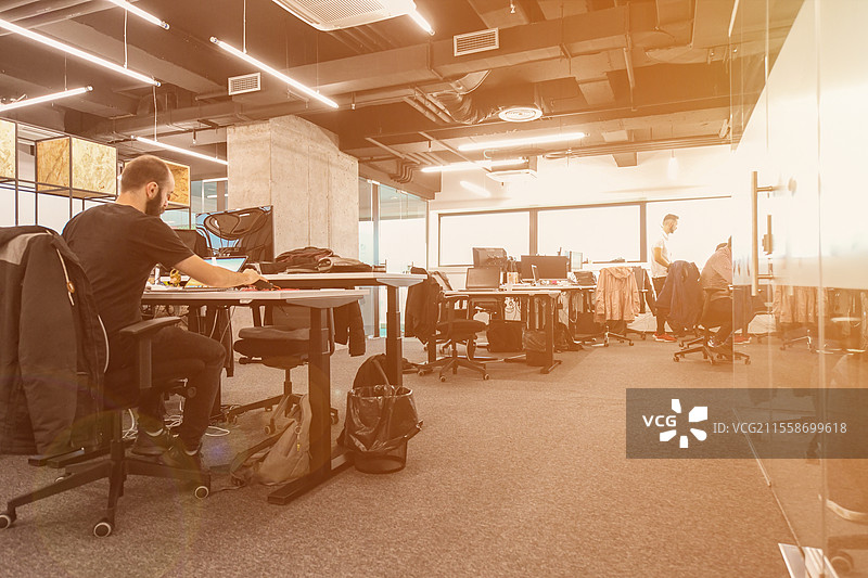 软件开发人员在现代阳光明媚的开放式办公室中日常工作，编写程序代码图片素材