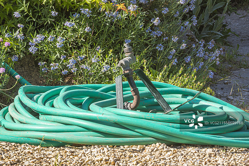 园艺水管盘绕在碎石上图片素材