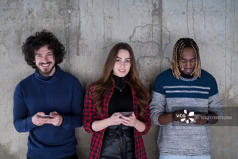 一群年轻快乐的学生在电子教室成功的一天后，用智能手机拍自拍照图片素材