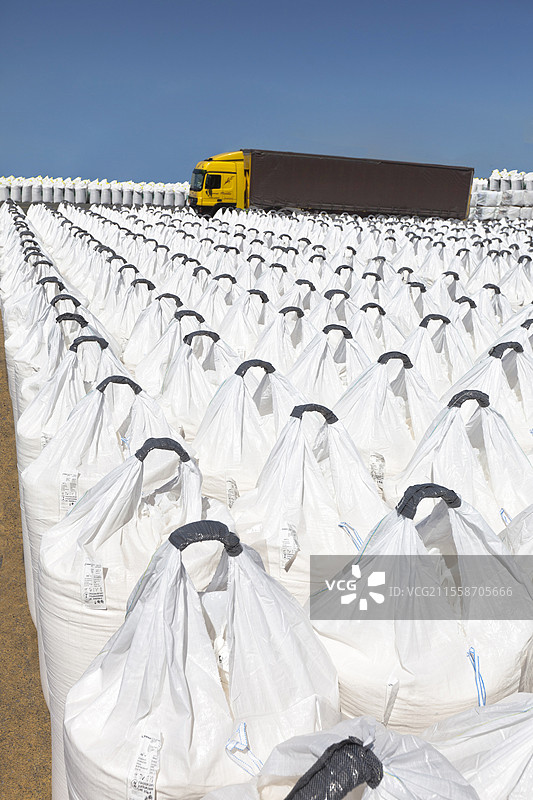 固体颗粒肥料的储存和包装，使用大袋装，氮肥、硝酸铵或二元或三元复合肥料。通过货船进口肥料，随后用卡车送货给客户，法国拉罗谢尔。图片素材