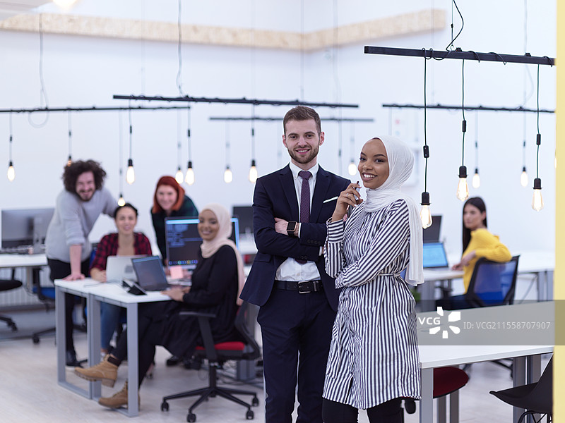 现代初创公司开放式共享办公空间的混合种族商业团队肖像，创意成功的多元化员工团队。图片素材