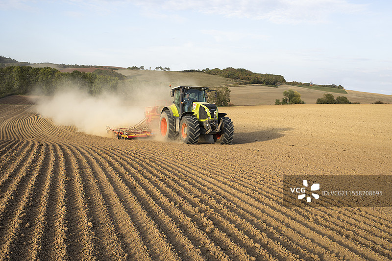 在干旱中，使用克拉斯拖拉机牵引的Vederstad播种机播种油菜、大麦或小麦。图片素材