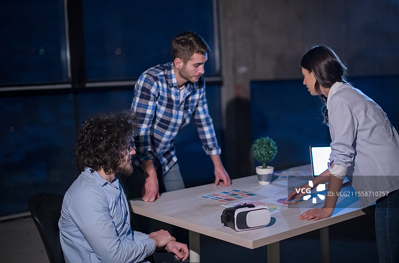 年轻的商业团队在建筑工地上，建筑师和工程师正在检查文件和业务流程，使用笔记本电脑在新的创业办公室中。图片素材