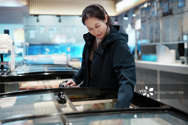 在现代零售环境中购买冰淇淋的年轻女性图片素材