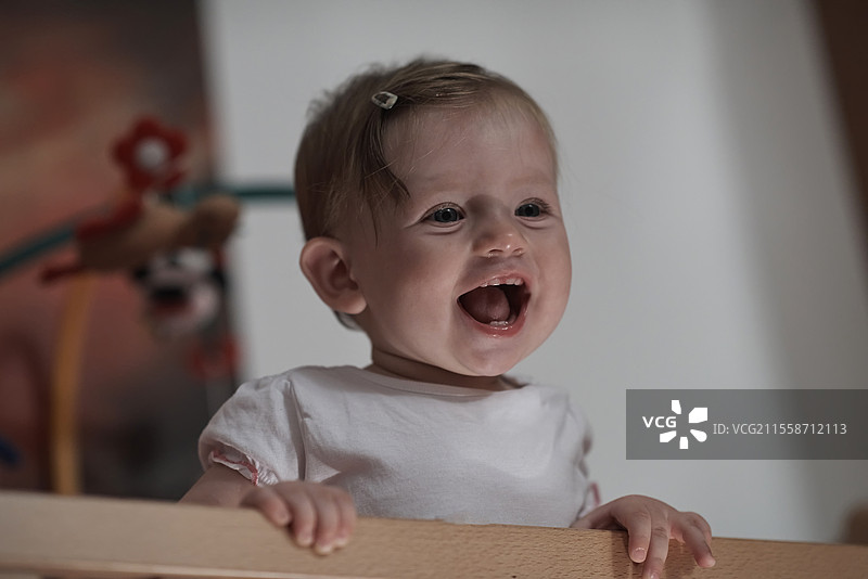 可爱的一岁小宝宝在床上玩玩具，迈出第一步，学习走路。图片素材