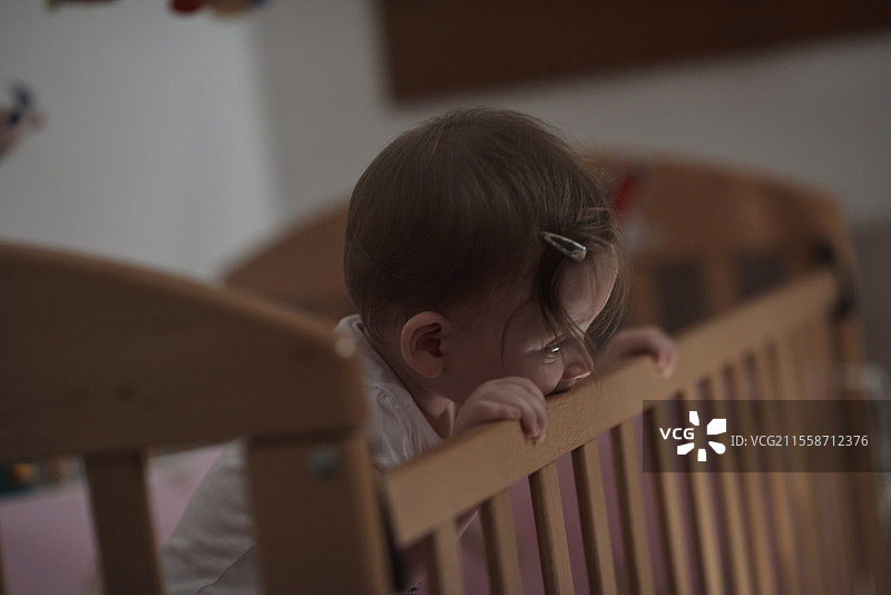 可爱的一岁小宝宝在床上玩玩具，迈出第一步，学习走路。图片素材