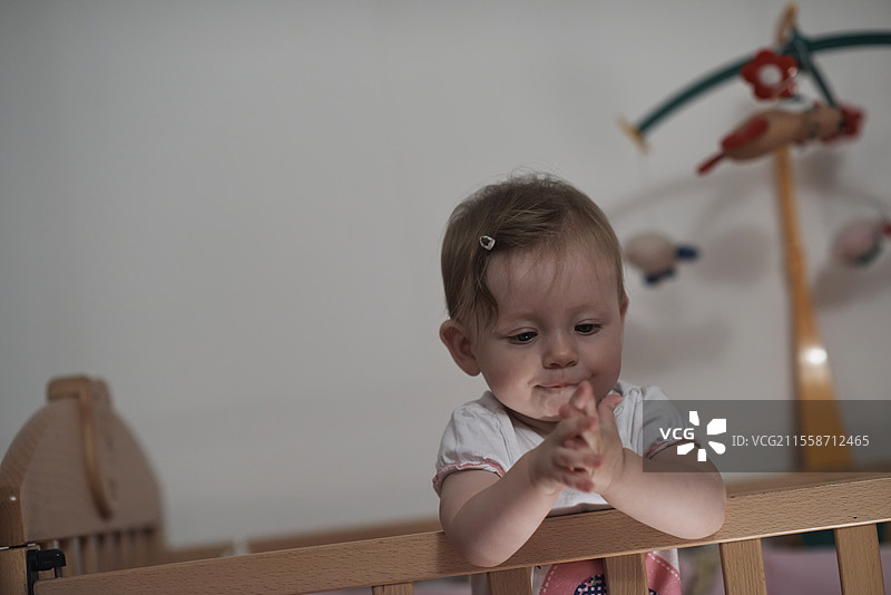 可爱的一岁小宝宝在床上玩玩具，迈出第一步，学习走路。图片素材