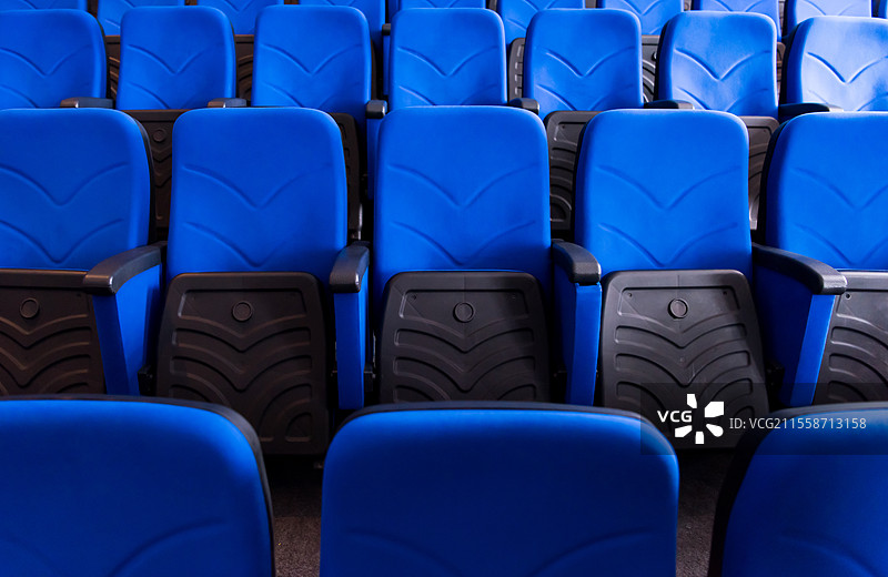 空荡荡的会议室、剧院或电影院，蓝色座椅整齐排列。图片素材