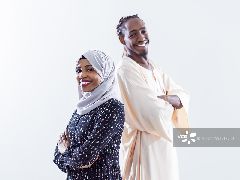 年轻非洲现代穆斯林夫妇穿着传统服装的肖像，背景为白色。图片素材