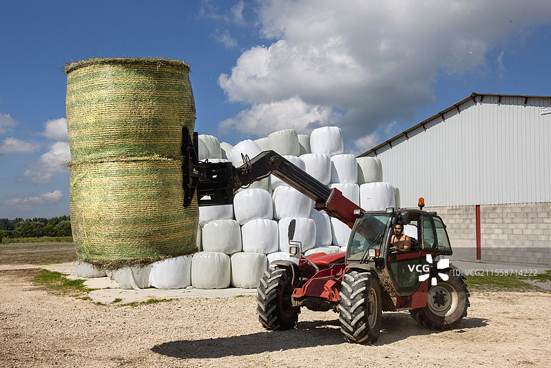 在法国卸载干草 bale 以进行农场储存和干草制作图片素材