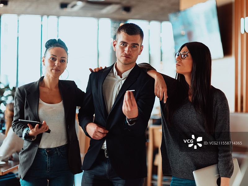 成功创意团队的肖像，面带微笑地看向镜头。多元化的商业人士在初创公司一起站立。成功的商业团队在办公室一起站立。图片素材